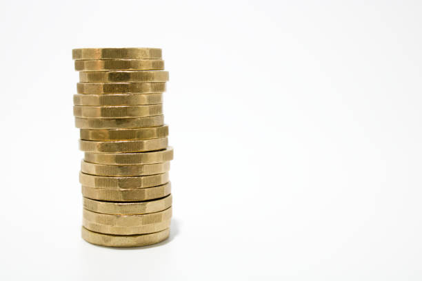Tall stack of one pound British coins Tall single stack of British one pound coins isolated on white background british currency stock pictures, royalty-free photos & images