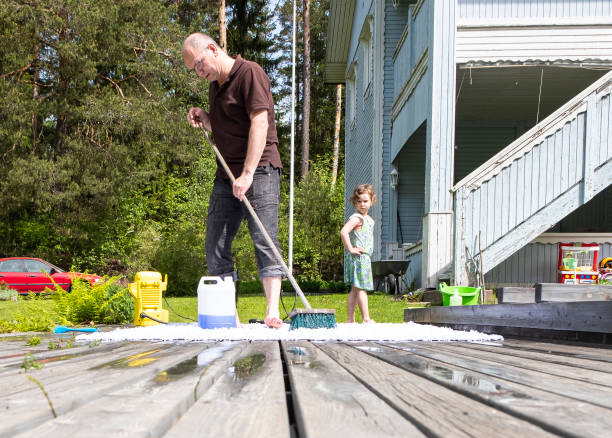 A Caucasian family is cleaning, with a brush, a white carpet on the terrace outside. A man and a girl of 6 years old. A Caucasian family is cleaning, with a brush, a white carpet on the terrace outside. A man and a girl of 6 years old. Cleaning in a country house. vacation rental cleaning stock pictures, royalty-free photos & images