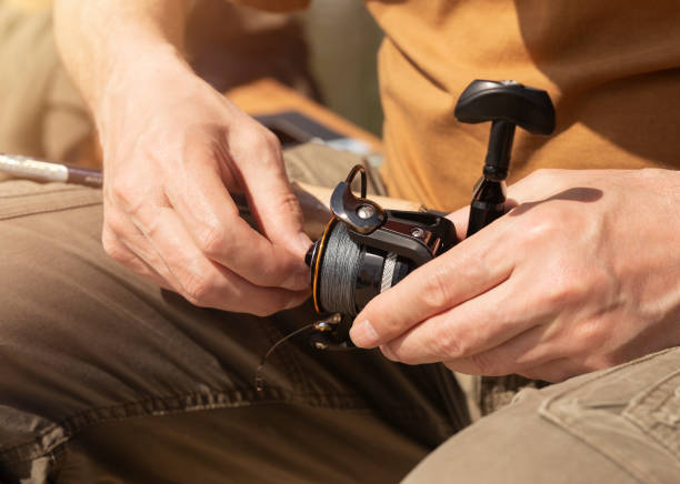 istock Male hands holding spinning rod, spoon-bait and and fixing or adjusting it before or after fishing, close up 1324223985