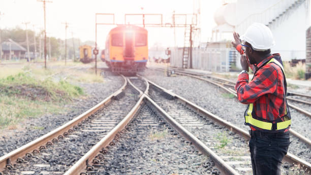 istock African engineer   raised a hand to control a the train on railway with talking by radio communication or walkie talkie 1324226078