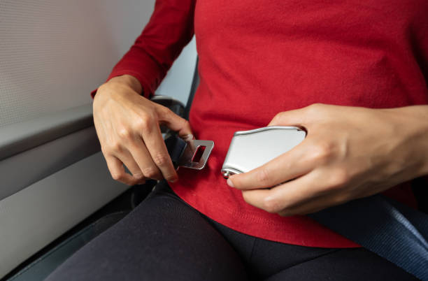 zbliżenie na pasażera podróżującego samolotem i mocującego pasy bezpieczeństwa - warning sign seat belt zdjęcia i obrazy z banku zdjęć