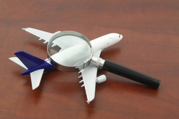 istock Checking tickets price. Airplane model under magnifying glass. 1324228715