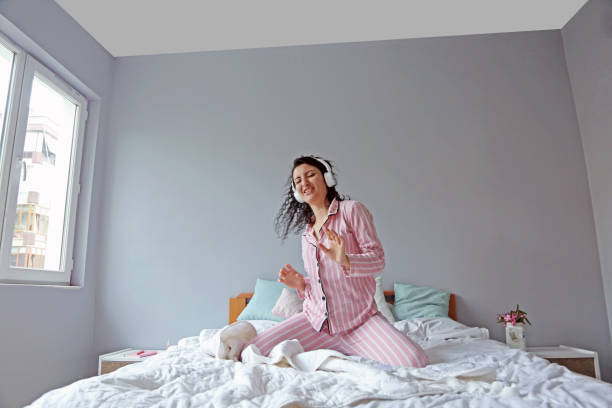 istock young beautiful woman waking up in her bed 1324230419