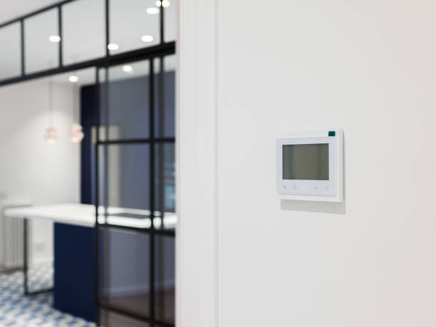 istock Console for controlling heating and cooling on the white wall in modern apartment. Wall-mounted control panel in a room for air-conditioning. 1324230672