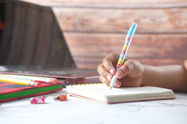istock child hand with pen writing on paper doing home work 1324231588