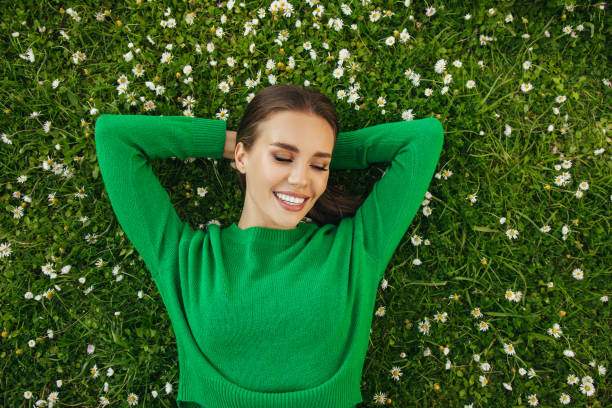 istock Beautiful woman lying on the grass 1324233932