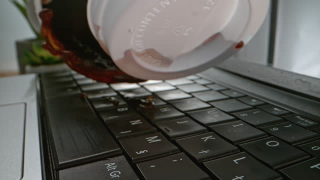 SLO MO LD To-go cup of coffee falling on a keyboard