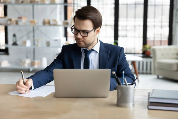 istock Serious male legal expert checking document at workplace 1324235299