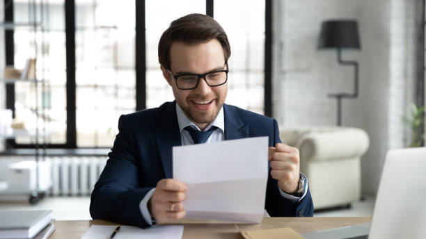 istock Happy businessman learning good news, reading letter, getting document 1324235340