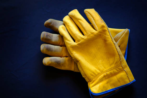 Fist, leather work glove on white background, high key.