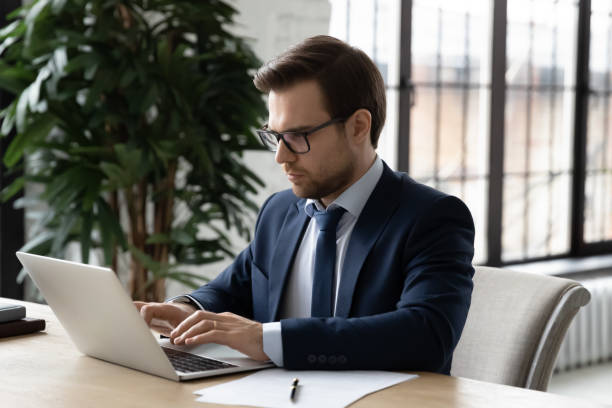 istock Focused businessman working at computer in office, typing, chatting 1324240306