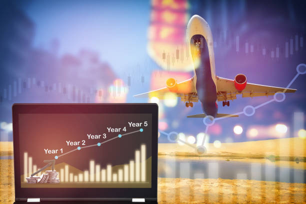 istock Stack of coins and five years growth graph on computer laptop on aircraft transportation background 1324240550