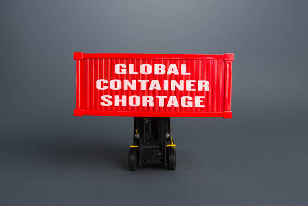 Forklift lifts the container with the inscription Global container shortage. Logistics problems due to world economy lockdowns. Limiting the volume of exports and increasing cost of transporting goods la carretilla elevadora levanta el contenedor con la inscripción escasez global de contenedores. problemas logísticos debido a los bloqueos de la economía mundial. limitar el volumen de las exportaciones y aumentar el costo del transporte de mercancías