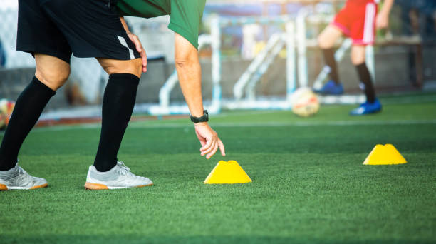 istock Coach or soccer player is putting the marker cones for soccer training to run and jump. 1324244607