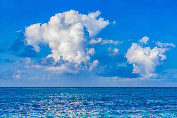 Colorful Large White Rain Cloud Blue Water Marker Reef Moorea Tahiti French Polynesia. Different blue colors from lagoon and coral reefs and outer reef waves and deep blue Pacific