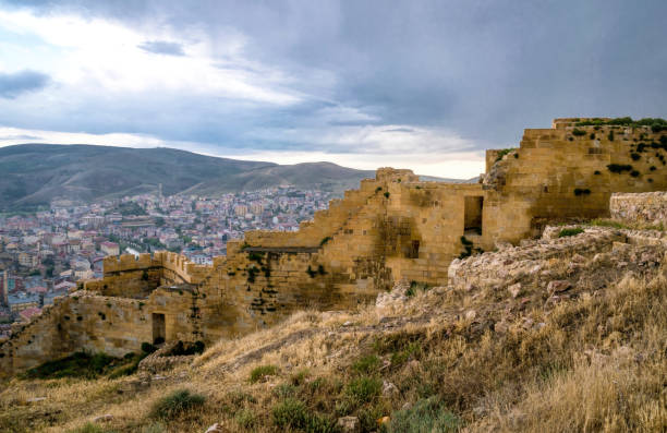Medieval ruined fortress Bayburt in Turkey Bayburt, Turkey - June 12, 2021:Ancient ruined Armenian fortress in the Turkish city of Bayburt. A picturesque cityscape in the evening - residential buildings along the river and an ancient castle against the backdrop of a blue sky. Traditional architecture of the ancient Near East bayburt stock pictures, royalty-free photos & images