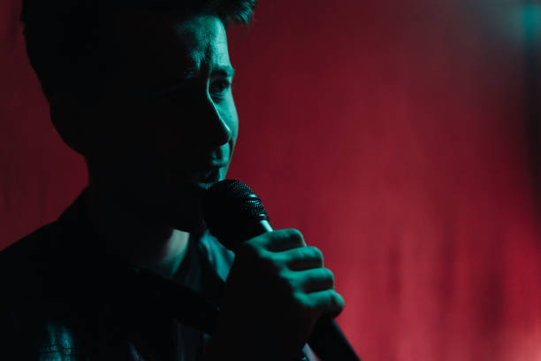 istock Man in leather jacket performing on a dark stage in club 1324247811
