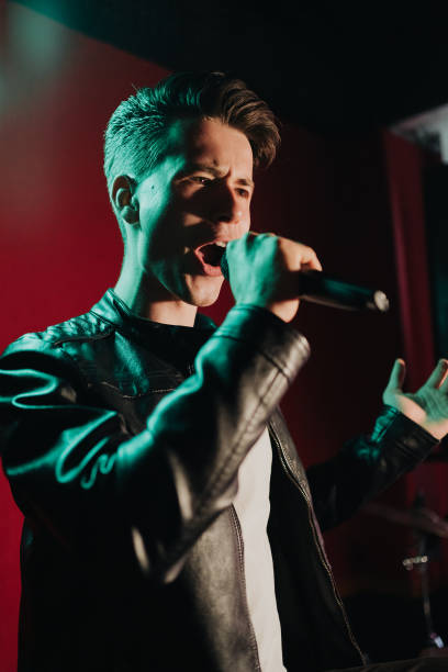 istock Man in leather jacket performing on a dark stage in club 1324247851