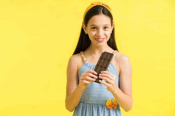 istock Cute girl looking at the camera with a chocolate 1324253147