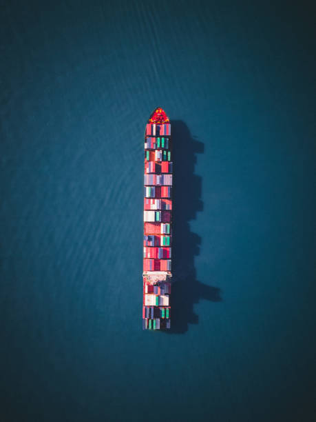 cargo ship filled with containers in different colors - navio cargueiro imagens e fotografias de stock