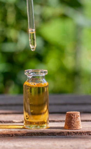 istock Essential oil bottle with pipette and drop, and bottle cup in the nature 1324256985