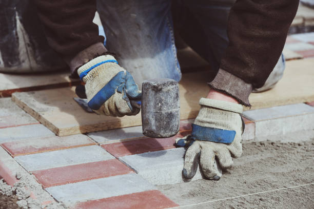istock Building worker hand lays paving slabs footpath 1324260199