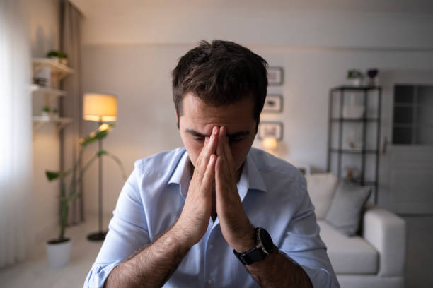 istock Man sitting alone at home looking sad and distraught 1324264433