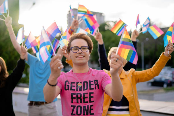 porträt eines lgbtq+-aktivisten, der regenbogenfahnen in den händen hält - gay pride flag gay pride gay man homosexual stock-fotos und bilder