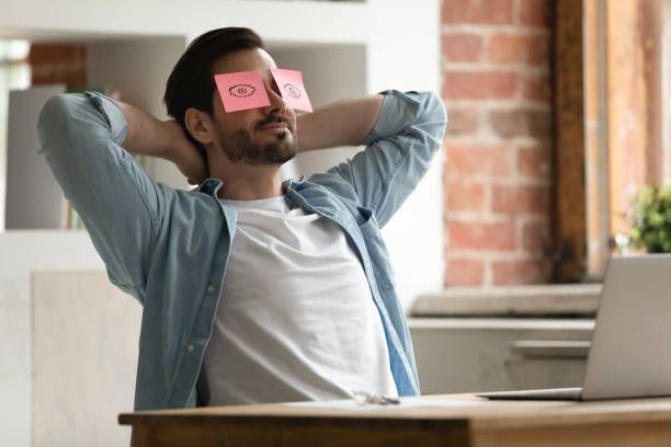 istock Peaceful young man relaxing with sticky paper notes on eyes. 1324266951