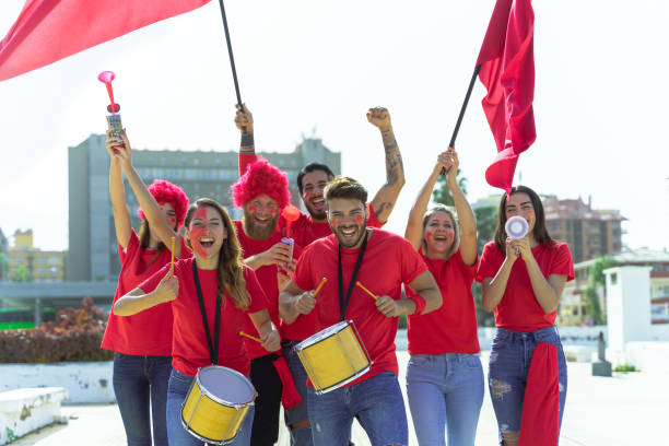 fan de football hurlant, avec des chemises rouges près du stade. groupe de jeunes très excités par le football. concept sportif et ludique. image - fan hooligan screaming shouting photos et images de collection