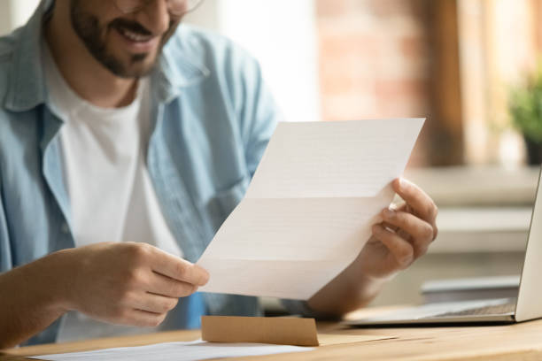 istock Close up young man holding paper correspondence in hands. 1324267922