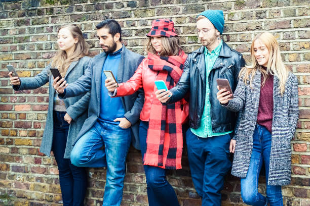 istock People using smart mobile phones app. Students addiction to new technology trends. Concept of youth, social and friendship - Image 1324270098