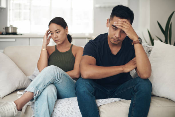 Shot of a young couple ignoring each other after an argument at home This is a tough issue to deal with blame photos stock pictures, royalty-free photos & images