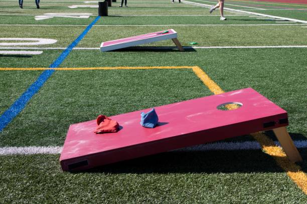 Cornhole and other games set up on a turf field for playing and having fun