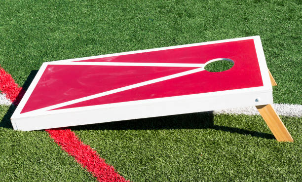 istock Red cornhole game with white trim on a green turf field close up 1324274650