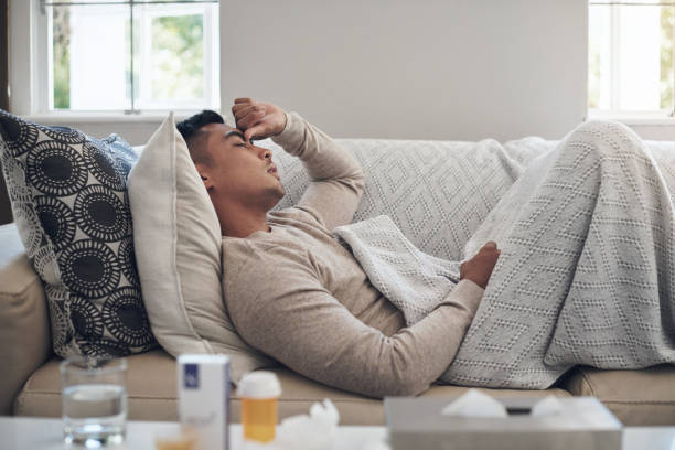 istock Shot of a young man experiencing a headache while feeling sick at home 1324276176