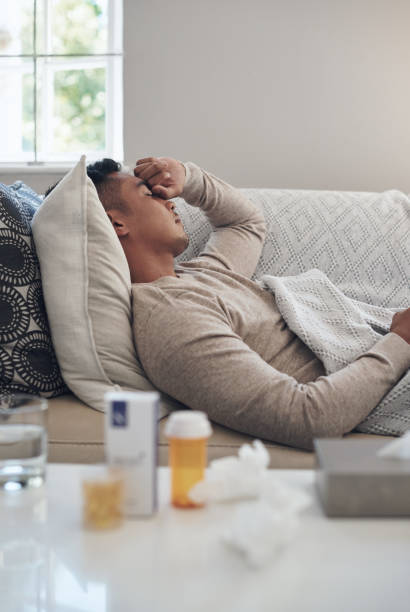 istock Shot of a young man experiencing a headache while feeling sick at home 1324276194