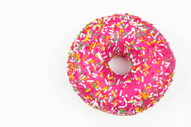 istock Pink donut decorated with colorful sprinkles. Flat lay. Top view 1324276330