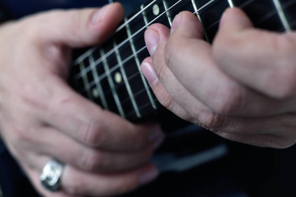 istock Hand with silver ring on his finger playing on semi-acoustic guitar. 1324282552
