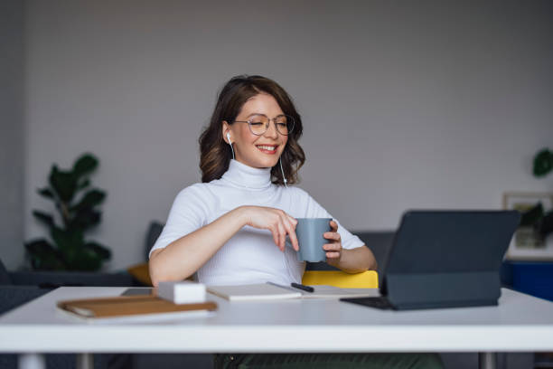 istock Work At Home: Young Businesswoman Holding  A Cup And Looking At Computer 1324283181