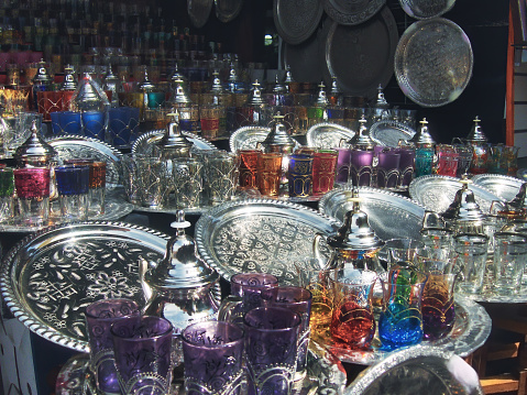 Traditional teapots and tea glasses displayed for sale on a street in the medina of Marrakech, Morocco.