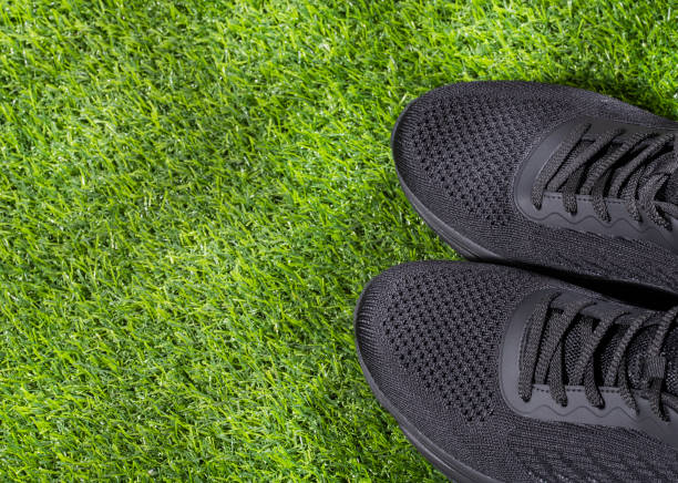 istock Two sports shoes on synthetic grass - Text space 1324288090