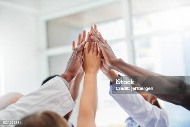Shot Of A Set Of Hands High Fiving In Victory Stock Photo - Download Image Now - Teamwork, High-Five, Healthcare And Medicine