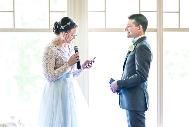 istock Bride and groom make speeches with microphone on their wedding day at the reception 1324299267