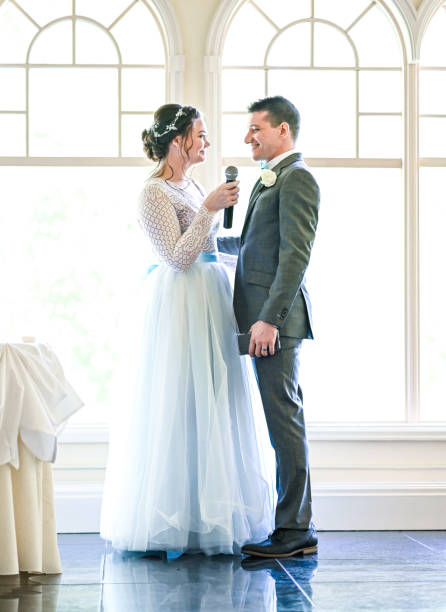 istock Bride and groom make speeches with microphone on their wedding day at the reception 1324299309