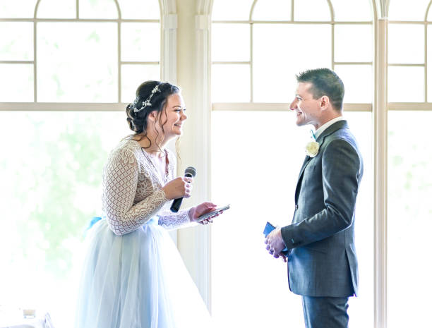 istock Bride and groom make speeches with microphone on their wedding day at the reception 1324299310
