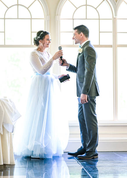 istock Bride and groom make speeches with microphone on their wedding day at the reception 1324299319