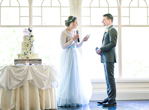 istock Bride and groom make speeches with microphone on their wedding day at the reception 1324299323