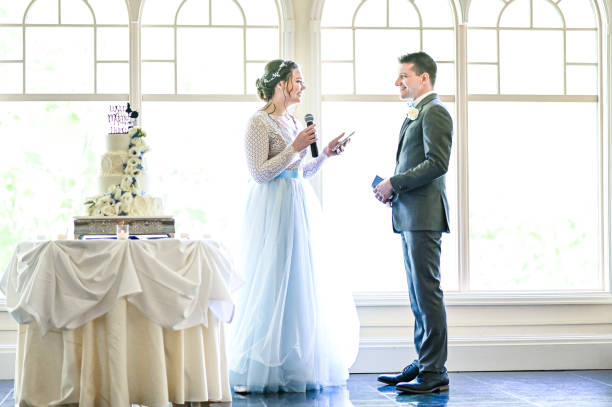 istock Bride and groom make speeches with microphone on their wedding day at the reception 1324299345