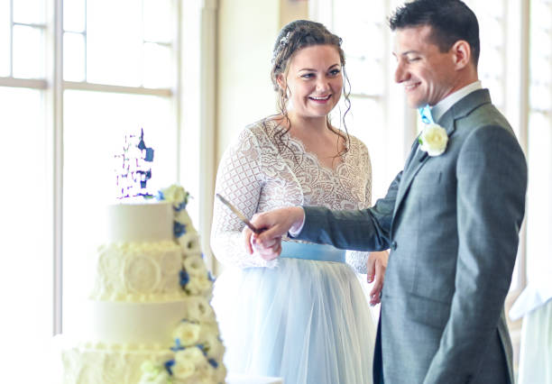 istock Bride and groom cut their wedding cake together at reception per tradition 1324299355
